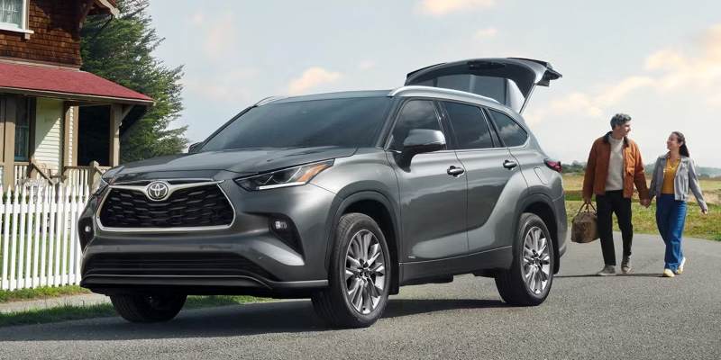 Gray Toyota Highlander SUV with open trunk outdoors.
